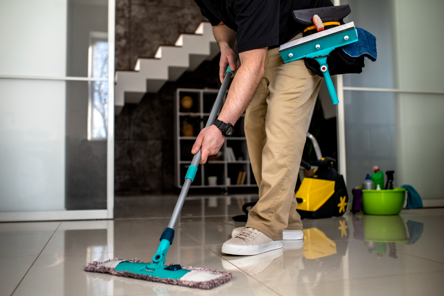 Rengøringsassistent mopper lyst flisegulv med professionelt udstyr — erhvervsrengøring